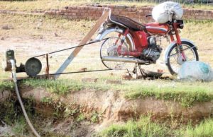 Illustration de l'innovation Jugaad avec une moto qui fait tourner une pompe à eau