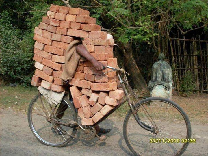 Illustration de l'innovation Jugaad avec une bicyclette sur laquelle l'agencement des briques a été optimisé pour maximiser la capacité de transport
